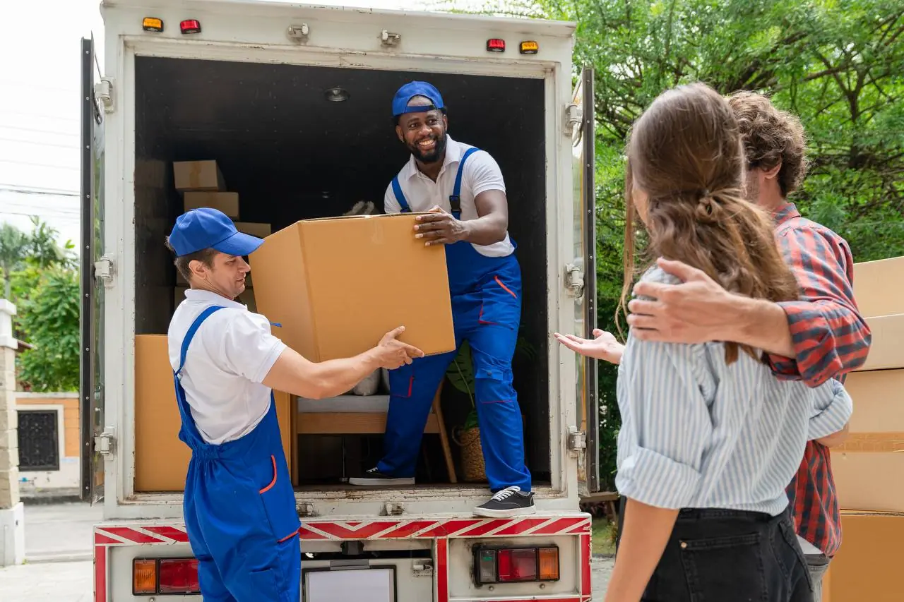Professional movers loading boxes into moving truck